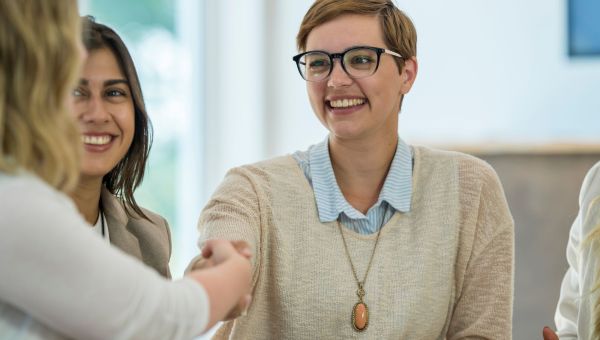 Young woman in glasses meeting conference member